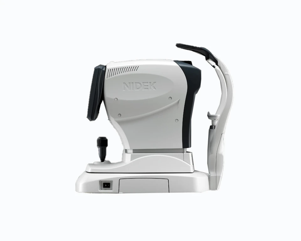 The Nidek Ophthalmic Instrument, Featuring A Sleek White And Black Body, Includes A Viewing Screen And Various Controls. Designed For Eye Examinations And Diagnostics, It Is Typically Found In Professional Eye Care Settings. The Device Also Boasts A Chin Rest And Ergonomic Handle For Added Comfort.
