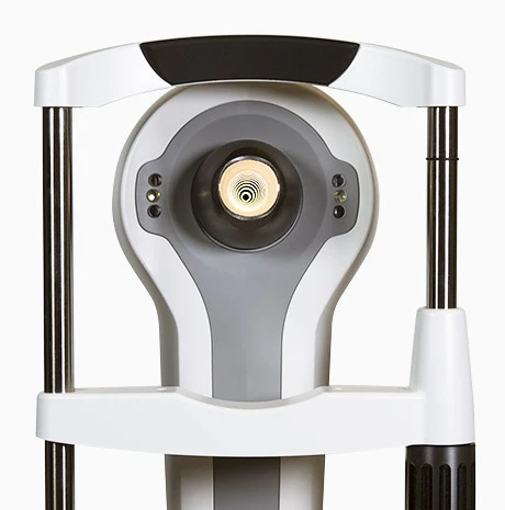 Close-Up Of An Ophthalmic Diagnostic Device, Specifically The Nidek Slit Lamp. The Device Features A Central Light Source Surrounded By Various Sensors And Is Equipped With Handles And Support Bars For Stabilization During Eye Examinations.