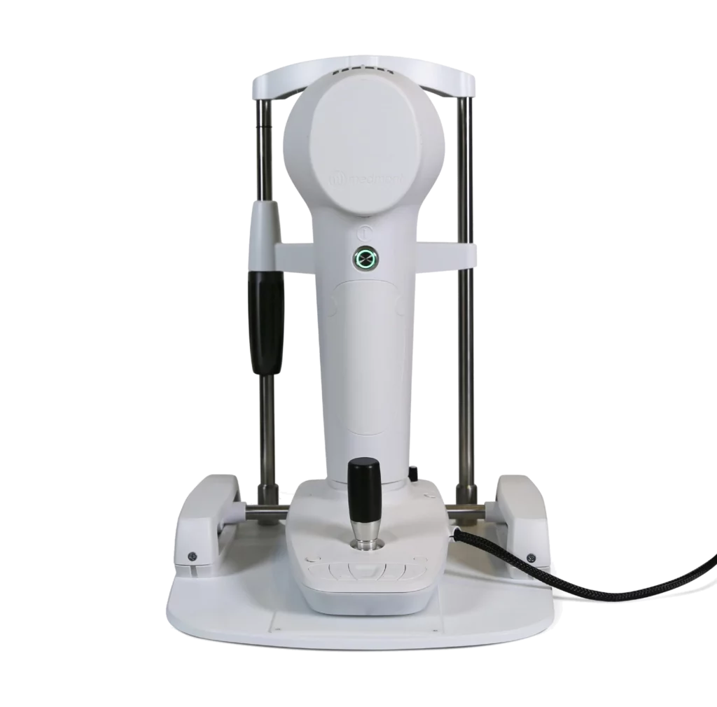 The Nidek Medical Imaging Device Features A White Exterior With A Vertical Central Unit, A Circular Top Section, And Two Parallel Metallic Support Rods. It Includes A Black Handle, A Circular Screen, And A Black Cable Extending From The Base. The Entire Apparatus Is Mounted On A Flat Base.