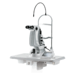 A Nidek Medical Device Featuring Dual Eyepieces On A Mounted Stand, Commonly Used For Eye Examinations. It Has A Sleek, Silver Finish, Various Controls, And Is Equipped With A Flexible Light Source. The Unit Is Positioned On A White, Flat Surface.
