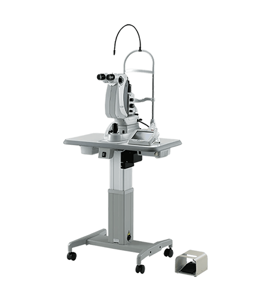 A Nidek Medical Device Used For Eye Examinations, Featuring Binocular Lenses, Mounted On A Height-Adjustable Stand With Wheels. A Foot Pedal Is Placed On The Floor Nearby For Operation. The Equipment Is White And Silver With A Contemporary Design.